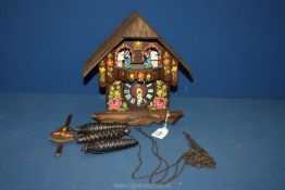 A 20th c. hand painted pine German cuckoo Clock complete with weights, chains and pendulum.