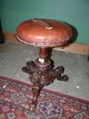 A Walnut Piano Stool with leather cushioned seat.