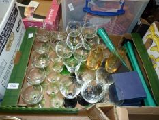 A quantity of coloured glass including long green stemmed wine glasses, black stemmed glasses,