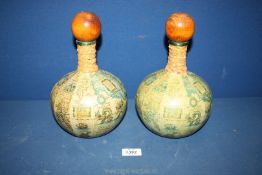 A pair of Old World Map decanters with wooden stoppers and leather around the neck,10'' tall.