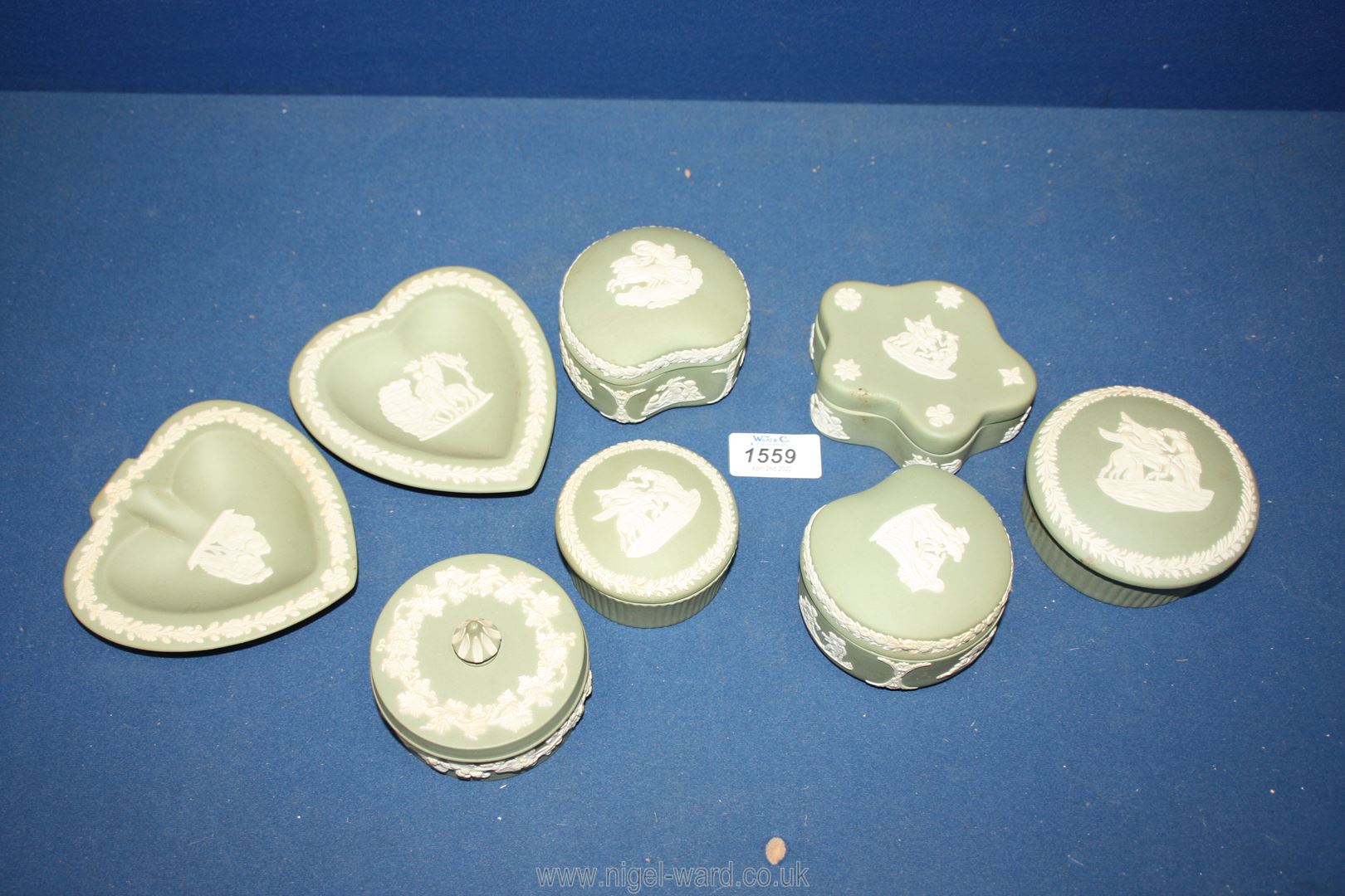 Eight pieces of green Wedgwood Jasperware including trinket pots and dishes.