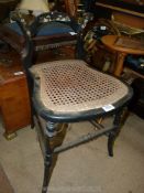 An ebonised framed Chair with mother of pearl detail and caned seat, (back rest cut down).