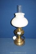An oil lamp with brass base, white shade and clear chimney, converted to electric, 19" tall.