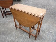An Oak gate-leg drop-leaf occasional table on turned supports,