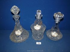 Three pressed glass decanters with stoppers and Coalport whisky, port and brandy tags.