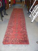 A red ground Runner, 29" wide x 9' 10" long (small amount of fraying to edge).