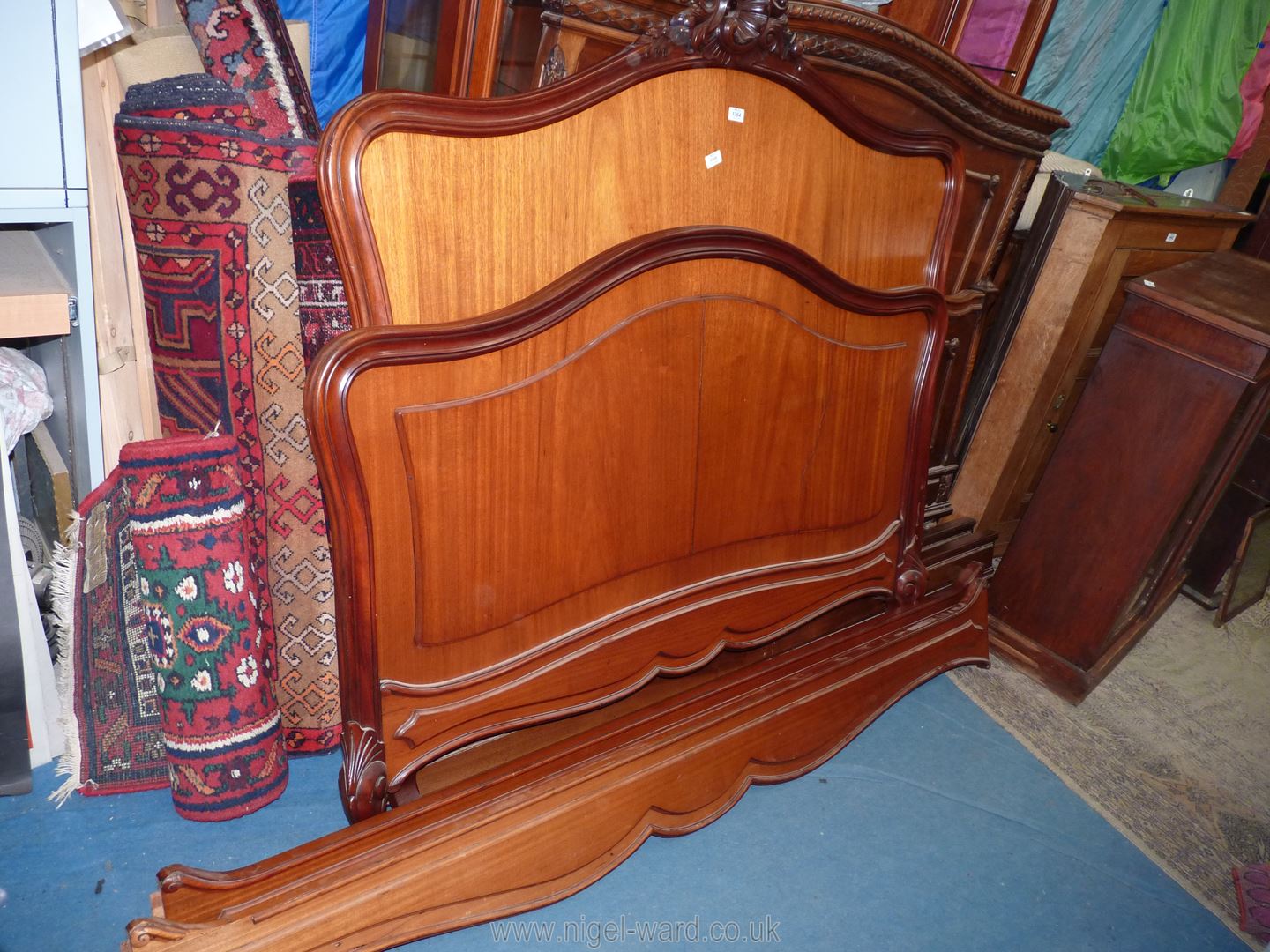 An elegant Mahogany double Bedstead standing on scroll legs, 60'' high x 83 1/2'' long overall.