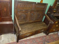 A peg joyned dark Oak Settle having open arms, a pair of frieze drawers below the seat,