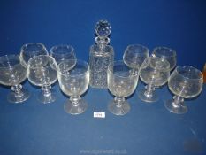 A glass decanter with stopper and eight heavy balloon style glasses plus two wine glasses.