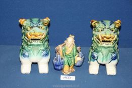 A pair of ceramic shaded green Temple Dogs, 6" tall, plus a water carrier figure a/f.