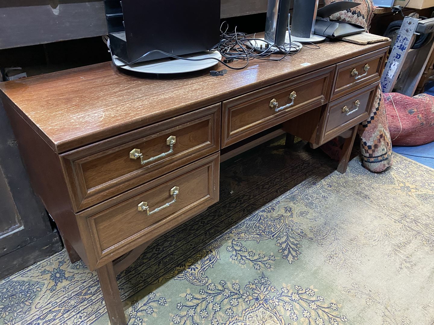 A "G-Plan" Teak finished Dressing Table/Desk having five drawers with brass finished drop handles