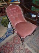 A Victorian Mahogany framed button back Chair upholstered in dusty pink Dralon and standing on