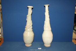 A matched pair of Chinese Celadon glazed Vases with applied dragons curling around the necks,