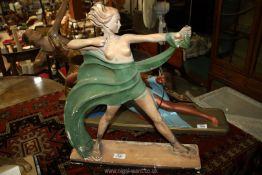 A plaster figure of an Art Deco woman standing holding a bow and arrow.