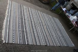 A fringed grey striped woven rug, 76'' x 114''.