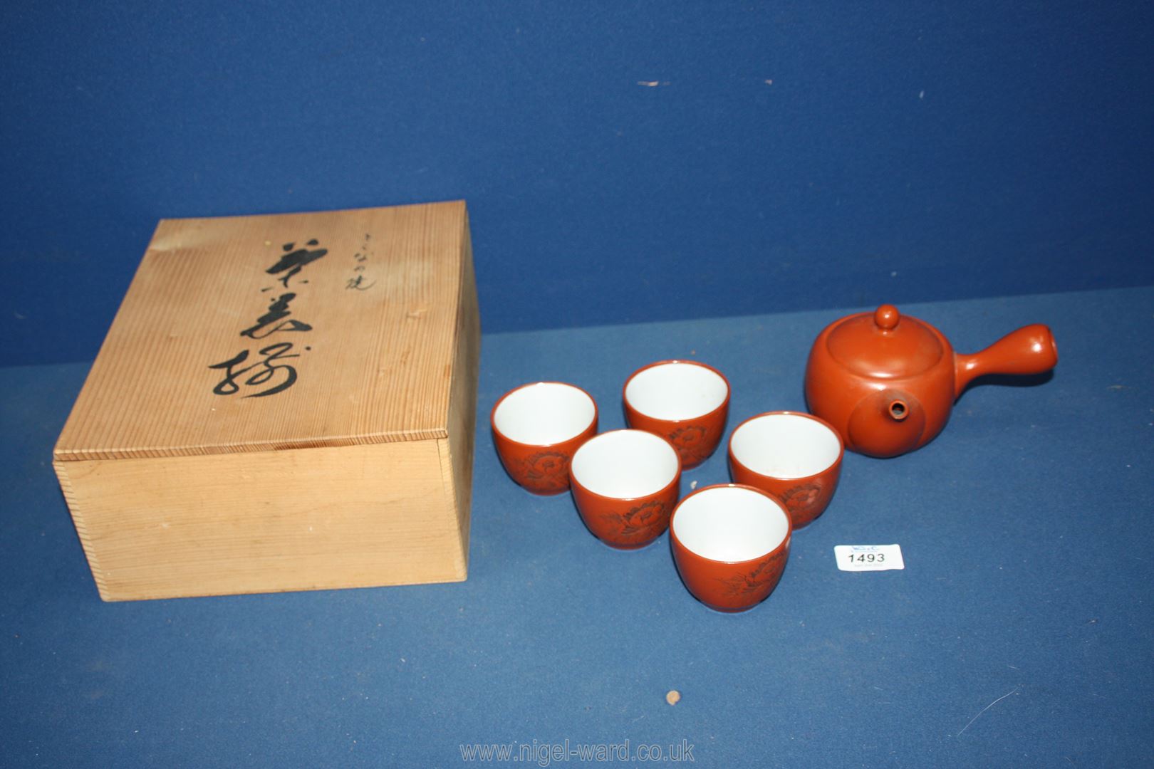 A Chinese Teaset in rust with white interior, held in a wooden case.