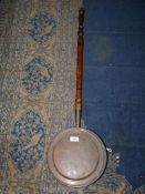 A large copper warming pan.