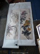 A pair of Japanese watercolours on silk brocade scrolls, depicting flowers and foliage,