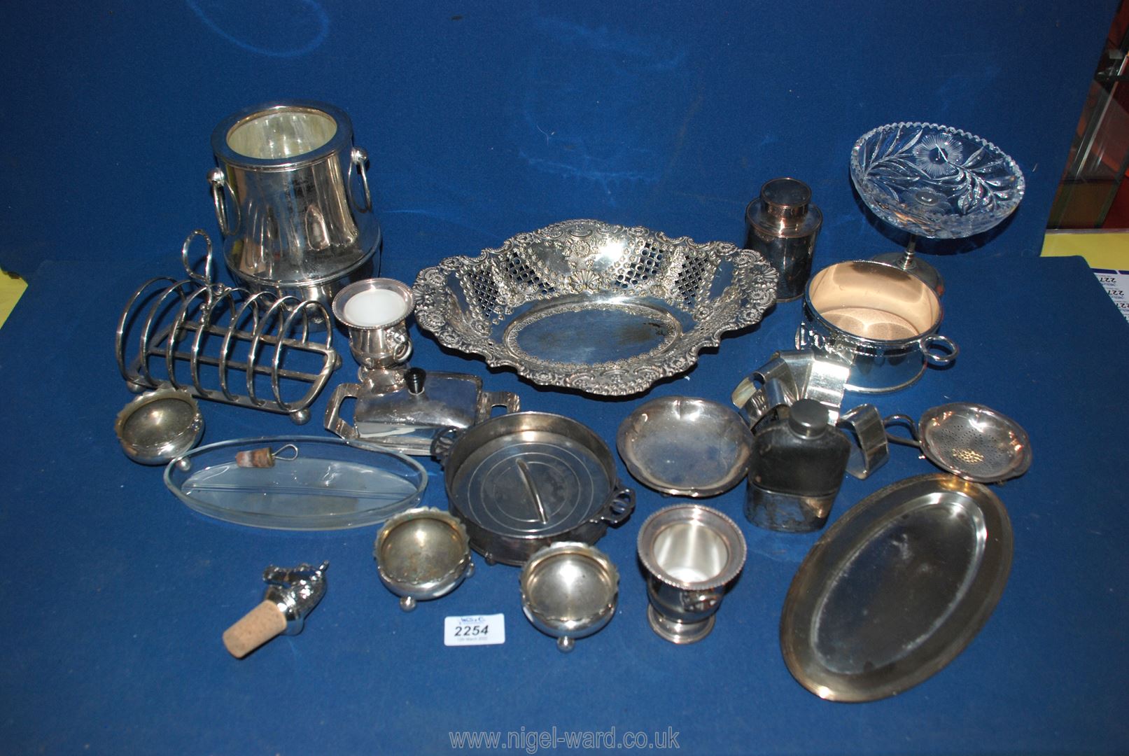 A box of various silver plate including an ice bucket, toast rack, napkin rings etc.