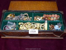 A long wooden box and contents of bracelets, clip on earrings etc.