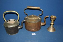 Two worn copper kettles both having brass handles, one with lid and a brass candlestick.