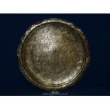 An Indian round solid polished brass tray decorated with figures and foliage having pierced and