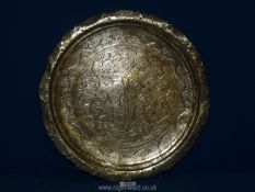 An Indian round solid polished brass tray decorated with figures and foliage having pierced and