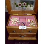 A jewellery box with four brooches including a cameo style.