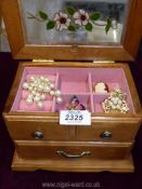 A jewellery box with four brooches including a cameo style.