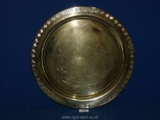 A solid brass, polished circular tray decorated with oriental figures etc.