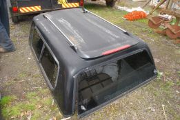 An L200 pick-up canopy having roof bars.
