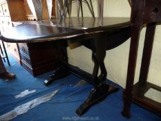 A black painted drop leaf table with refectory style base