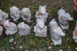 Eight concrete garden ornaments, goblins, foxes and dogs.