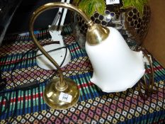A small brass table lamp with glass shade.