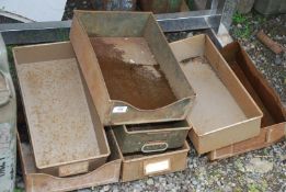 Seven metal storage trays of various sizes.