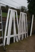 Five large wooden A-frame stands with peg holes.