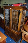 A reproduction lounge display cabinet with glass shelves and lights.