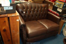A Thomas Lloyd brown leather two seater button back sofa.