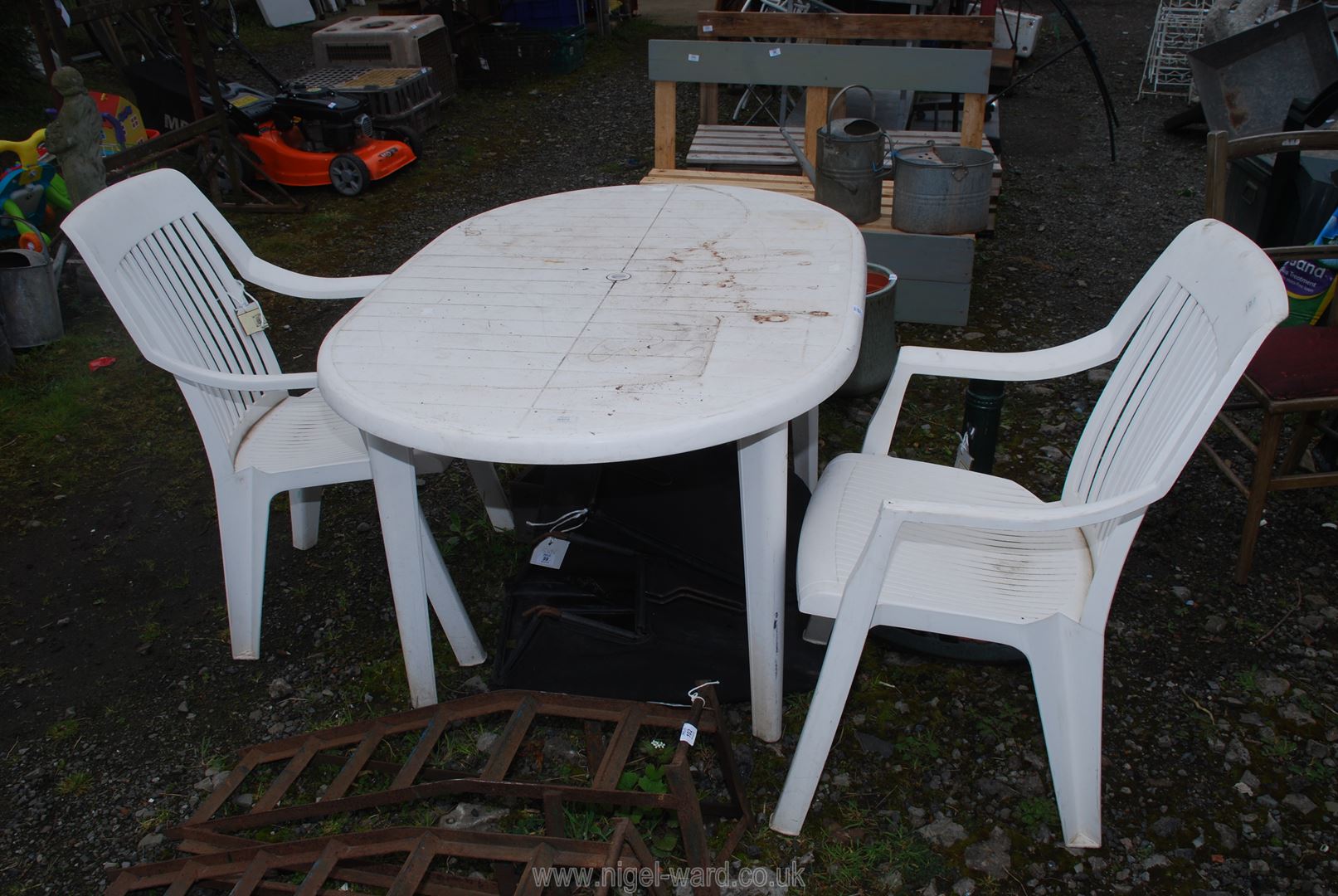 A plastic patio table, 53'' x 35'' x 27'' and two chairs.
