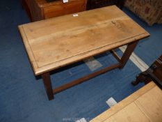 A stripped oak lounge table with stretcher base,