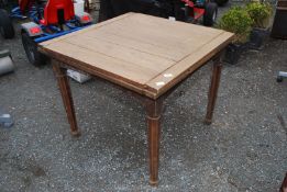 A light oak extending dining table, 36'' square (closed).