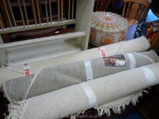 Three cream coloured rugs.