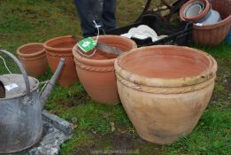 A set of four matching terracotta pots, various sizes.