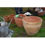 A set of four matching terracotta pots, various sizes.