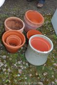 A quantity of mixed size terracotta pots and a glazed planter.