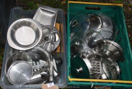 Two plastic crates of stainless steel cookware.