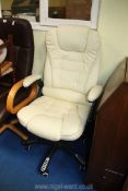 A cream faux leather office chair.