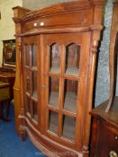 An Indian Redwood bow fronted corner display Cabinet, 41'' wide x 32'' deep.