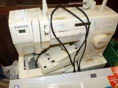 A Singer electric sewing machine with soft cover.