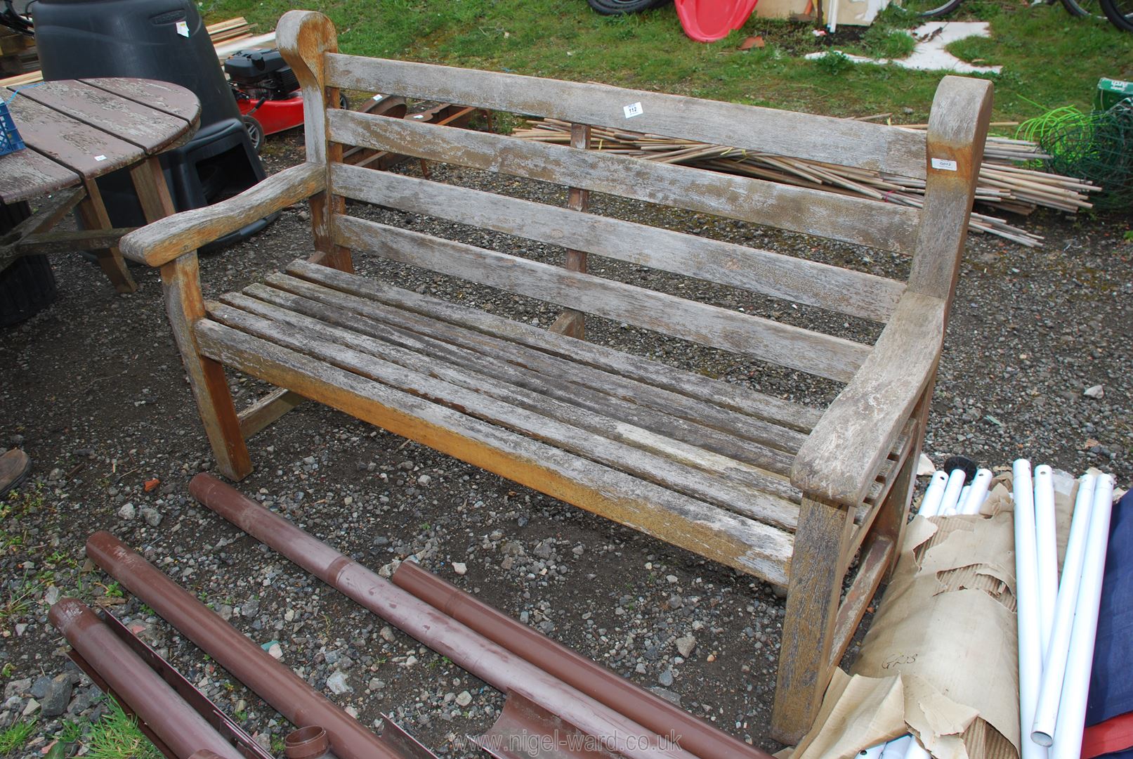 A wooden (appears to be Teak) garden bench, 61'' long, 39'' high.